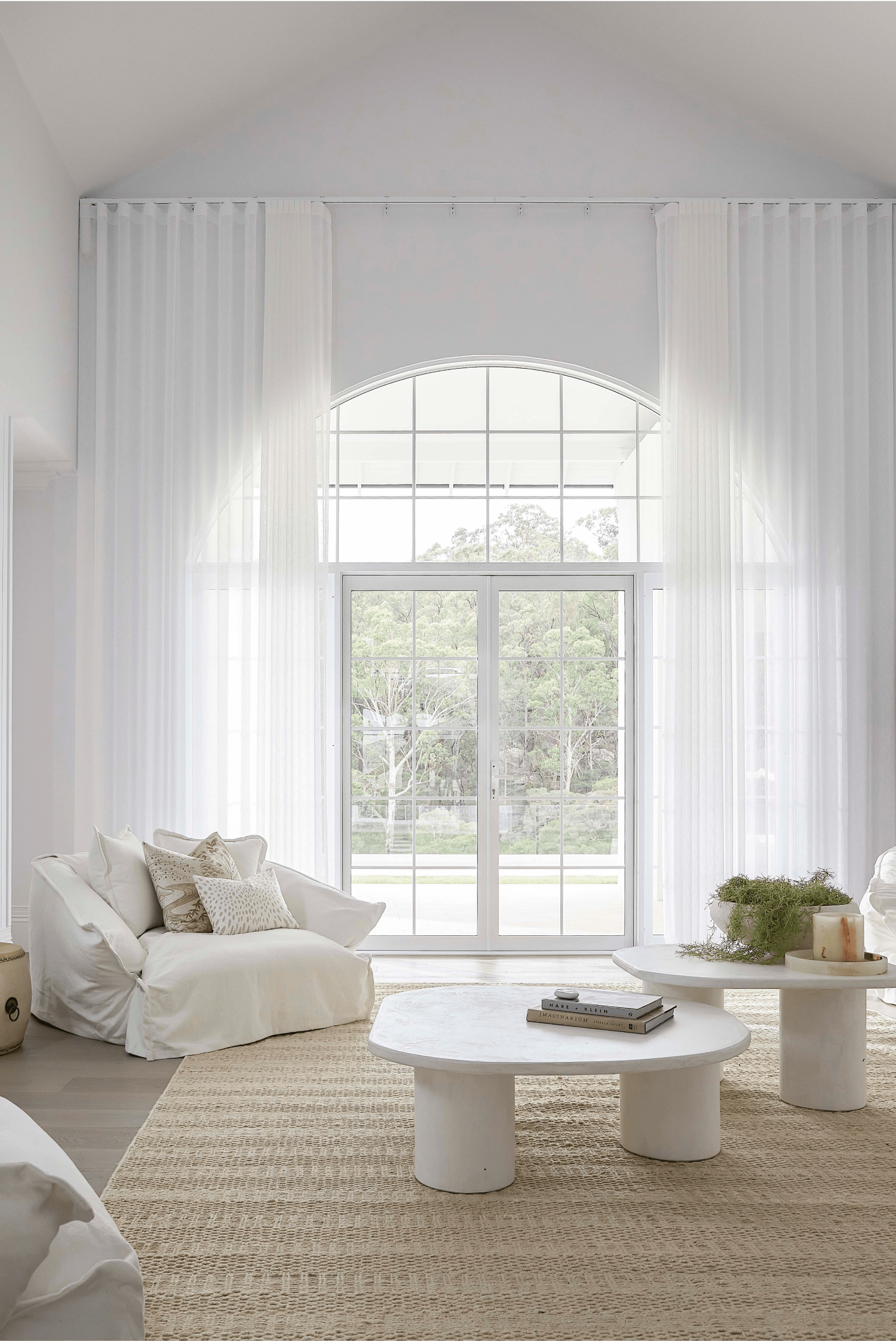 Elegant Sheer Curtains for Light-Filled Living Bright living room with tall white sheer curtains framing large arched window
