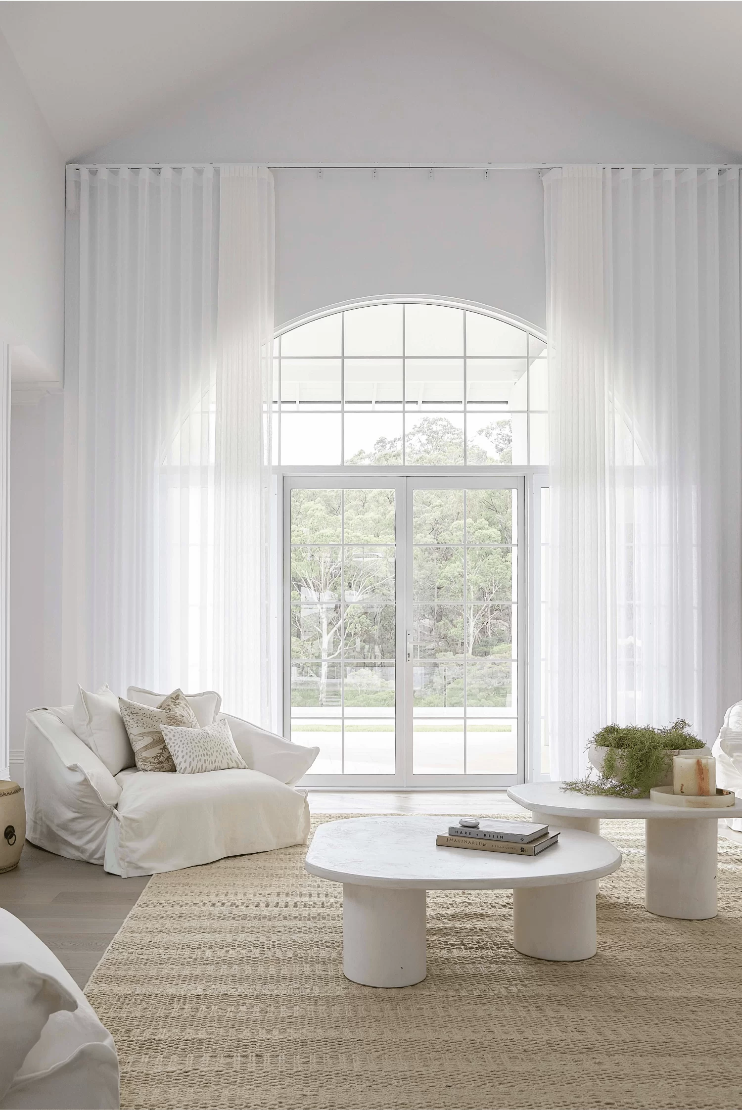 Elegant Sheer Curtains for Light-Filled Living Bright living room with tall white sheer curtains framing large arched window